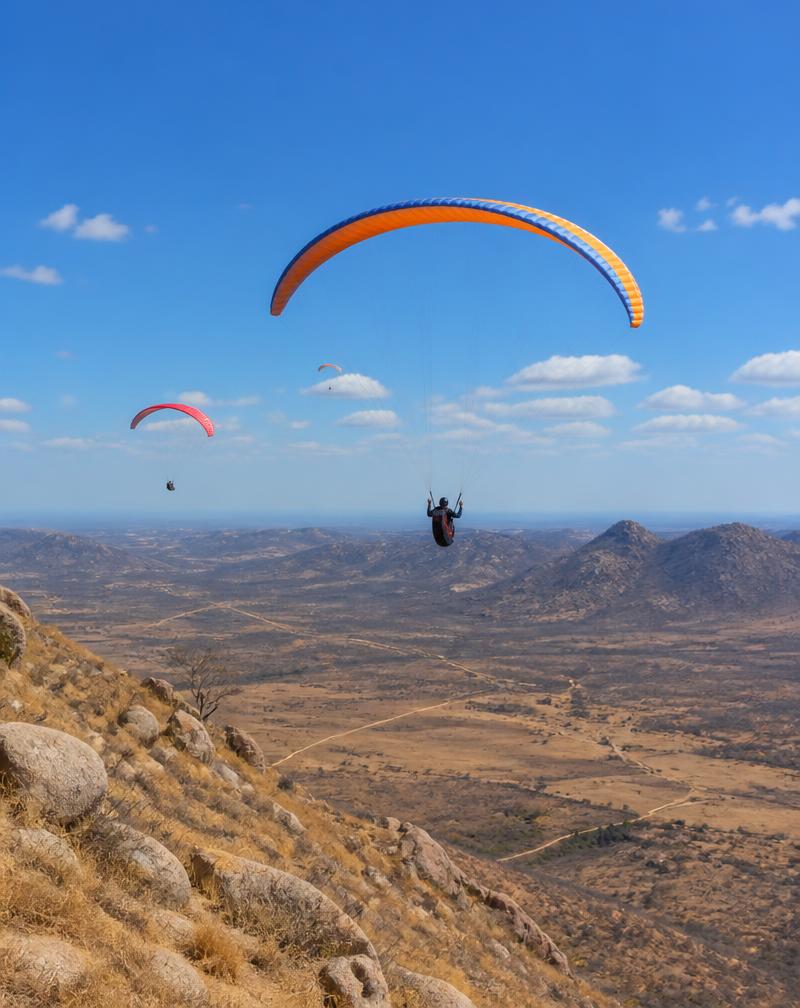 Parapentes voando sobre a paisagem árida da Serra do Lima em Patu